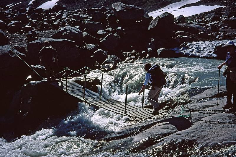 August 5, 1997 - From Finse to the Hardangerjkulen (glacier) and back, Norway.<br />Joyce about to cross a suspension bridge over glacier melt.