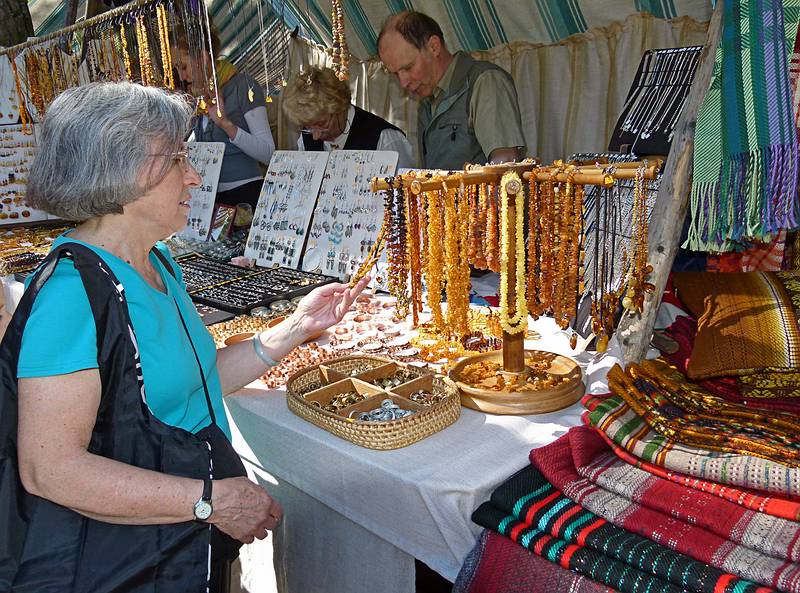 Joyce inspecting some amber necklaces.<br />Arts and crafts fair at the Latvian Ethnographic Open Air Museum.<br />June 4, 2011 - Riga, Latvia.