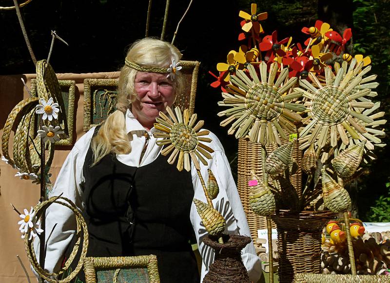 Woman whose hair matches the wares.<br />Arts and crafts fair at the Latvian Ethnographic Open Air Museum.<br />June 4, 2011 - Riga, Latvia.