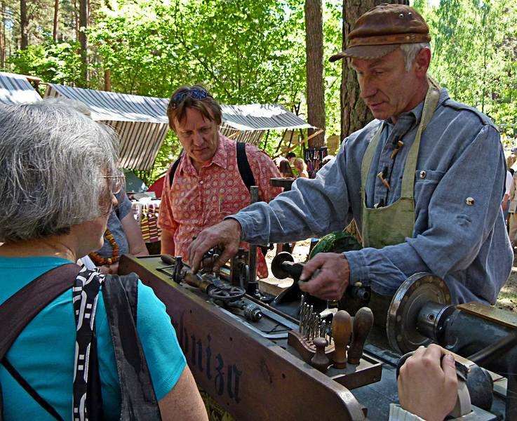 Joyce watching an artist who works with animal horns.<br />Arts and crafts fair at the Latvian Ethnographic Open Air Museum.<br />June 4, 2011 - Riga, Latvia.